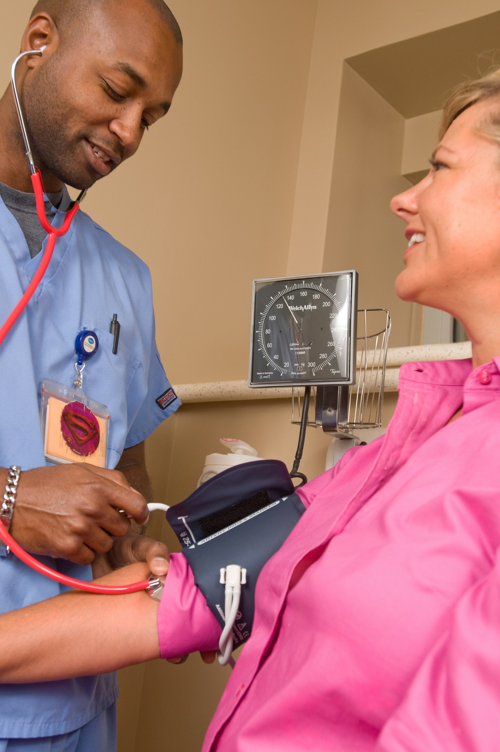 A clinician checking a patient's blood pressure at home